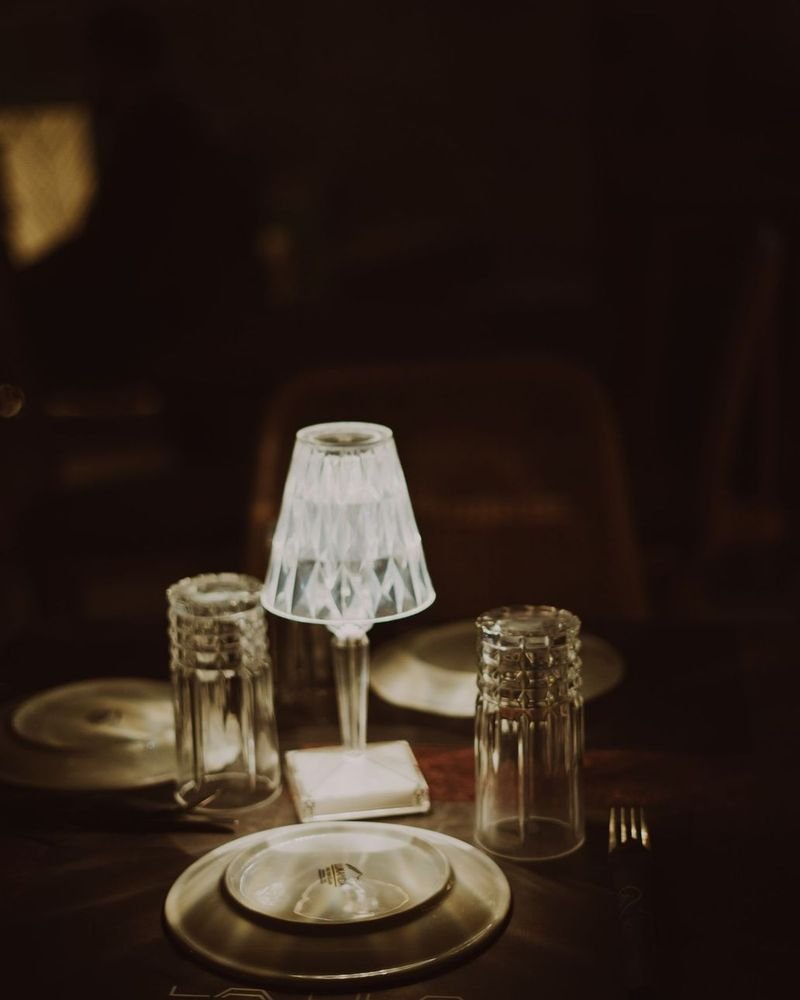 Campaign still: a cut-glass cordless lamp on a candlelit dinner table