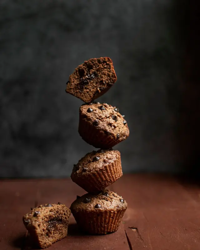 A tower of chocolate cupcakes on dark wood