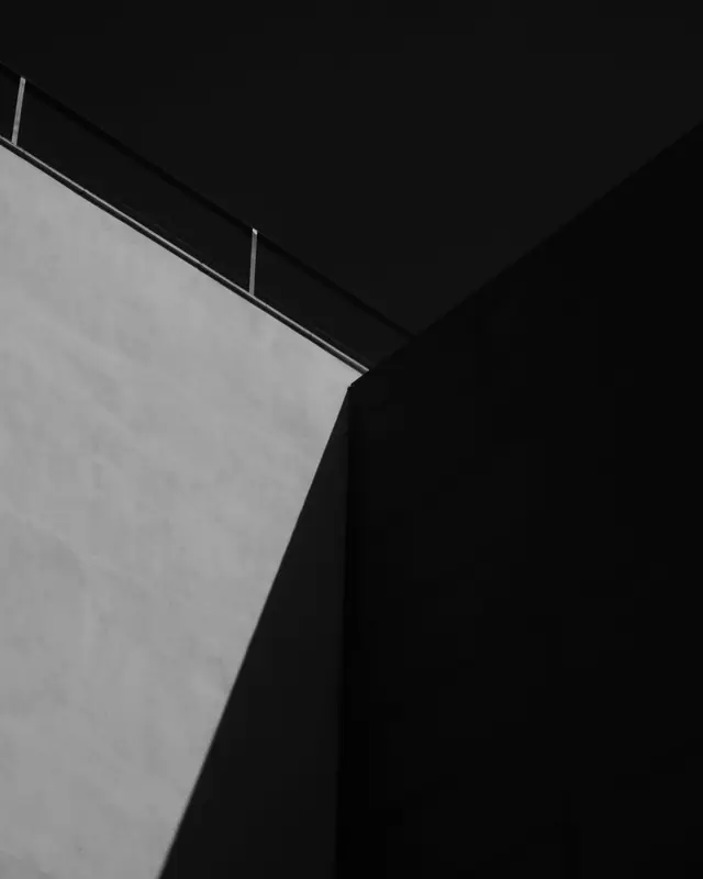 A black and white building edge against a dark sky