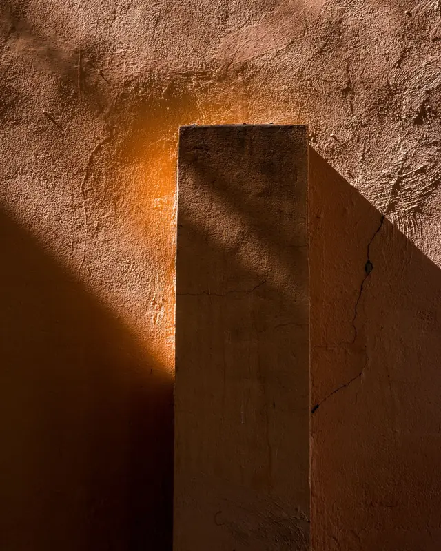Low sun on an ochre wall and pillar